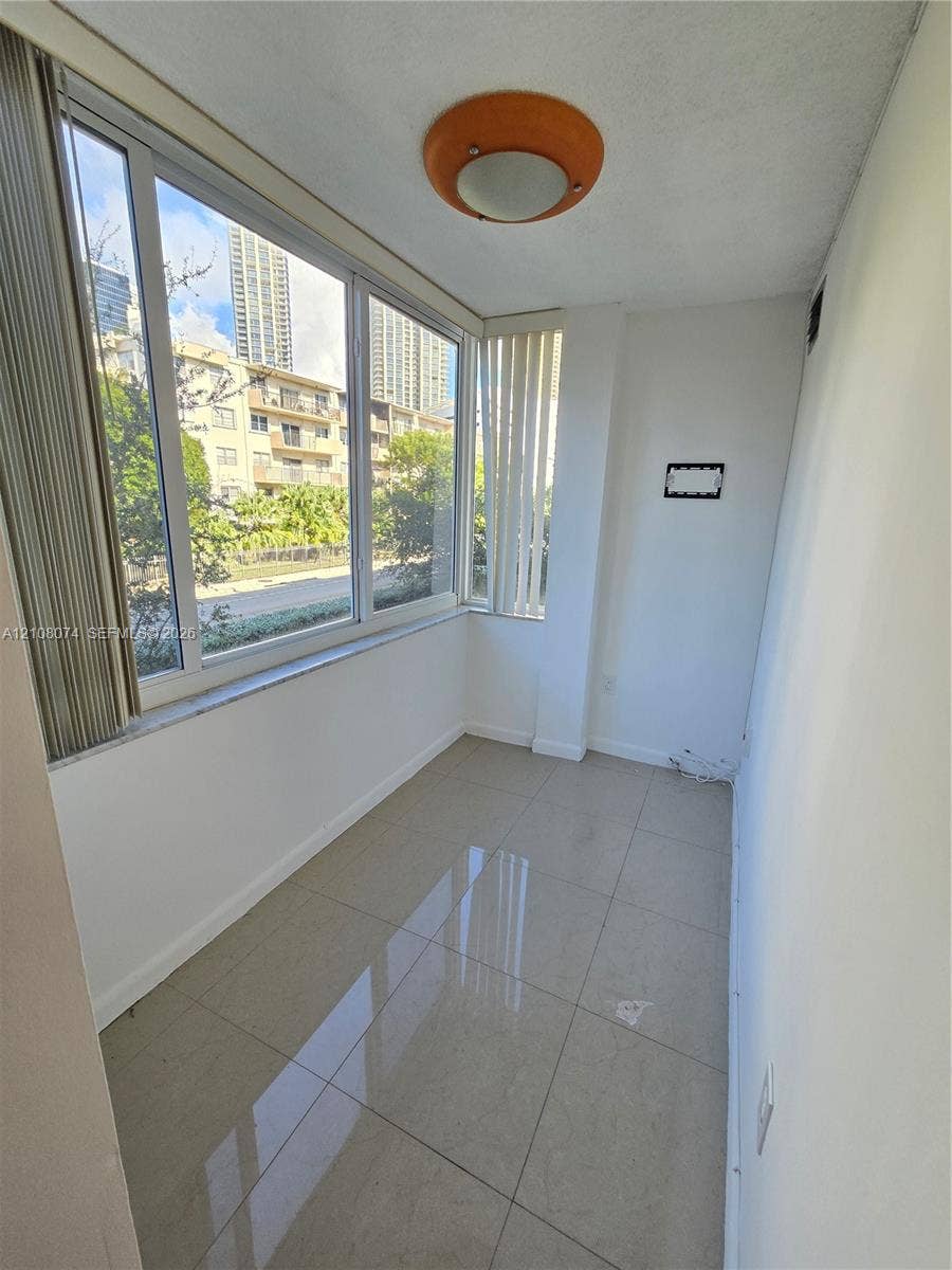250 180th Drive, #202, Sunny Isles Beach, Sunny Isles Beach, FL 33160 Enclosed space featuring oversized windows, light-tone tile flooring, and a flush-mount dome light fixture