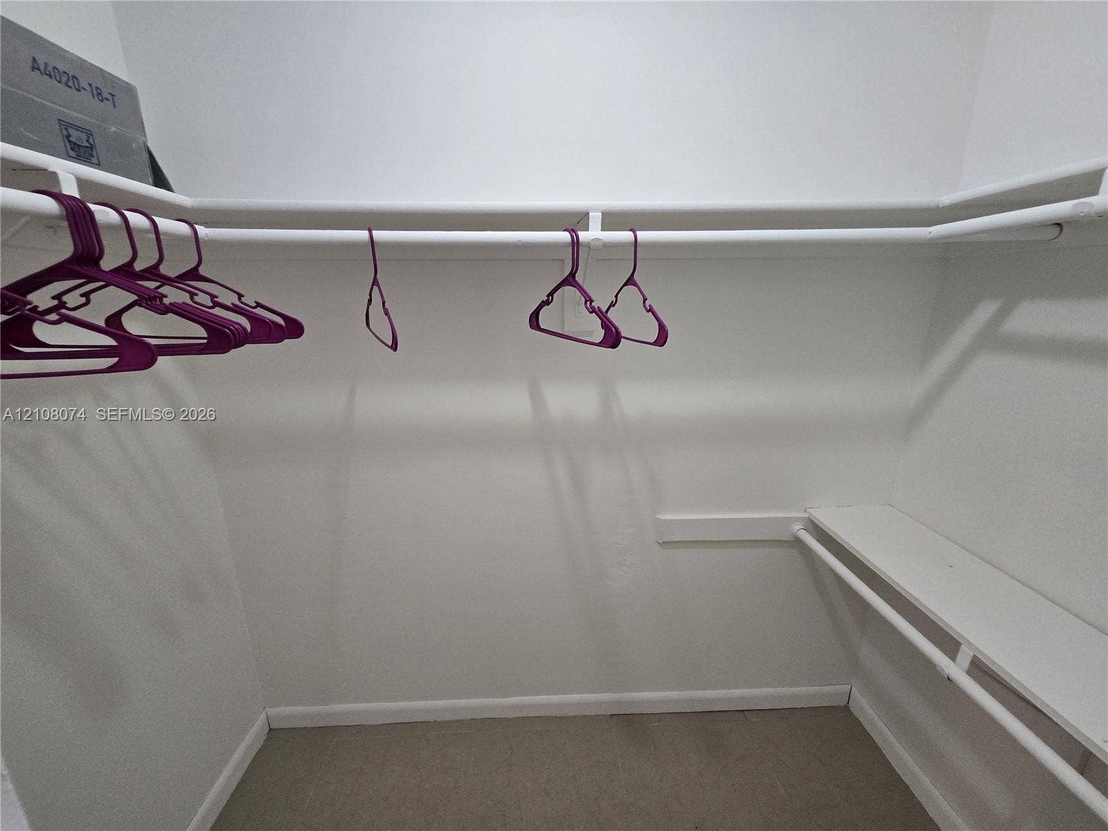 250 180th Drive, #202, Sunny Isles Beach, Sunny Isles Beach, FL 33160 Walk-in closet featuring white wall-mounted shelving and dual-tier clothing rods