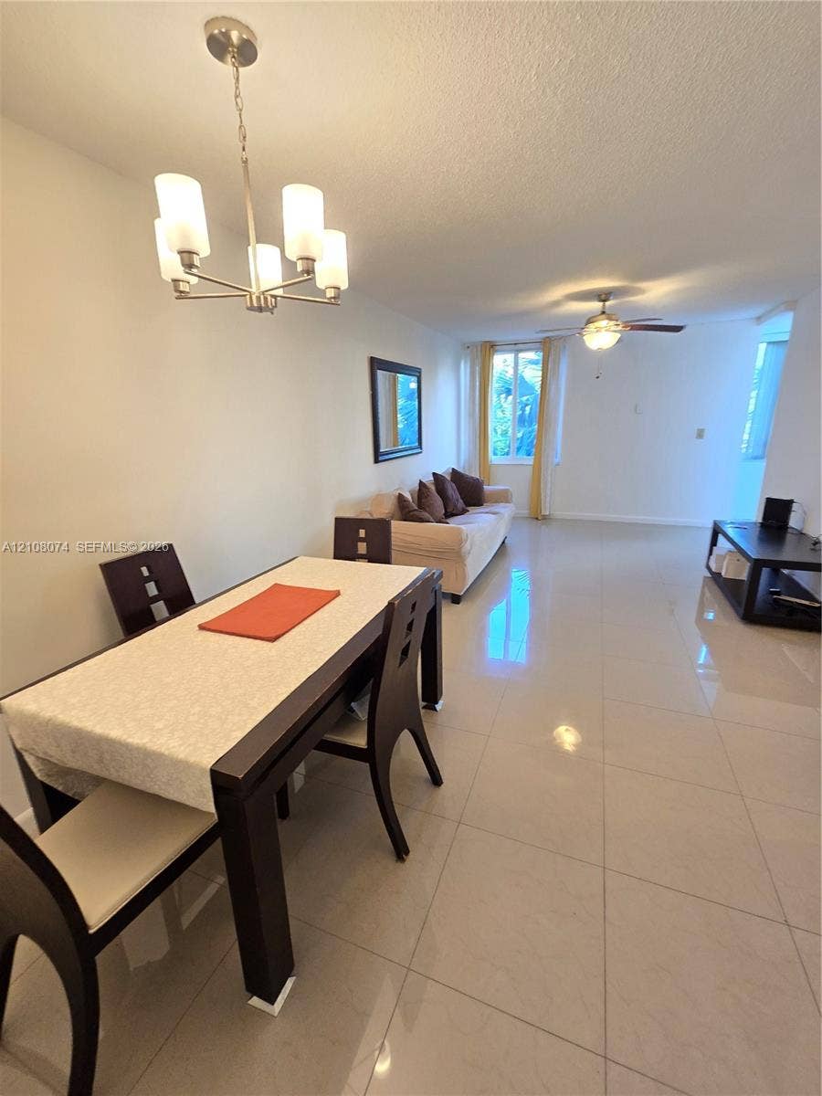 250 180th Drive, #202, Sunny Isles Beach, Sunny Isles Beach, FL 33160 Large-format tile flooring, multi-light chandelier, and ceiling fan with integrated lighting