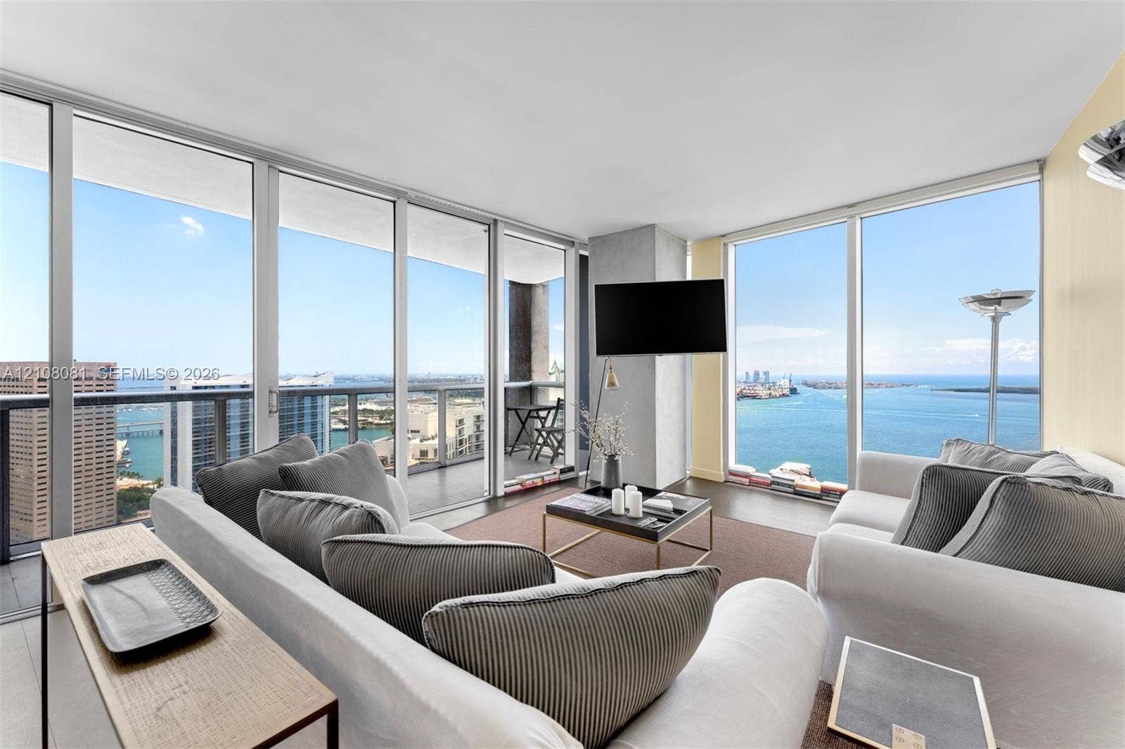495 Brickell Avenue, #4502, Miami, FL 33131 Floor-to-ceiling glass walls, expansive balcony with metal railing, and neutral tile flooring