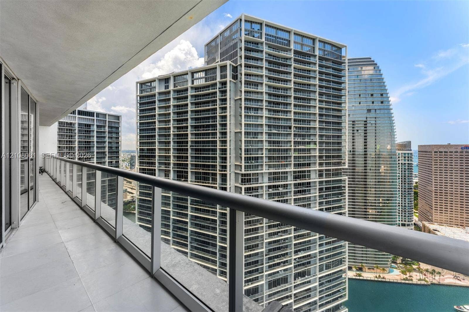 495 Brickell Avenue, #4502, Miami, FL 33131 Private balcony featuring large-format tile flooring, a glass-panel railing, and a metal handrail