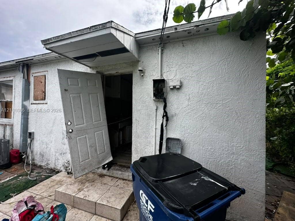 Stucco exterior featuring a raised covered entryway and tiled stoop