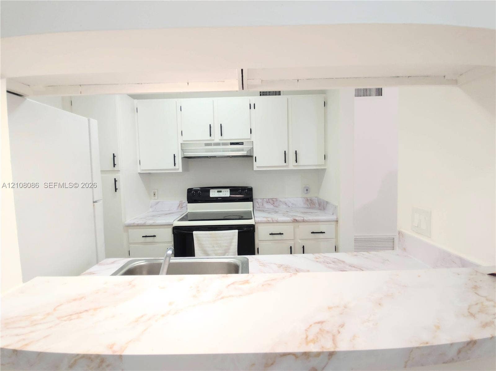 4401 W Mcnab Road, Pompano Beach, FL 33069 Kitchen featuring white cabinetry with matte black hardware, stone-finish countertops, stainless steel sink, and electric range
