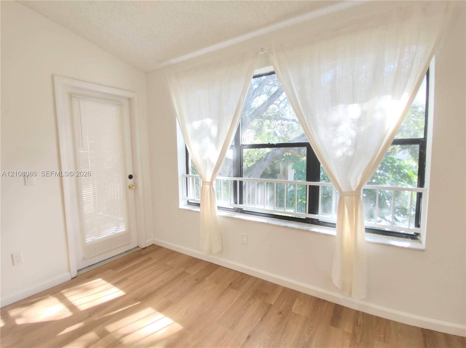 4401 W Mcnab Road, Pompano Beach, FL 33069 Large windows featuring natural light, wood-finish flooring, and a glass-paneled entry door