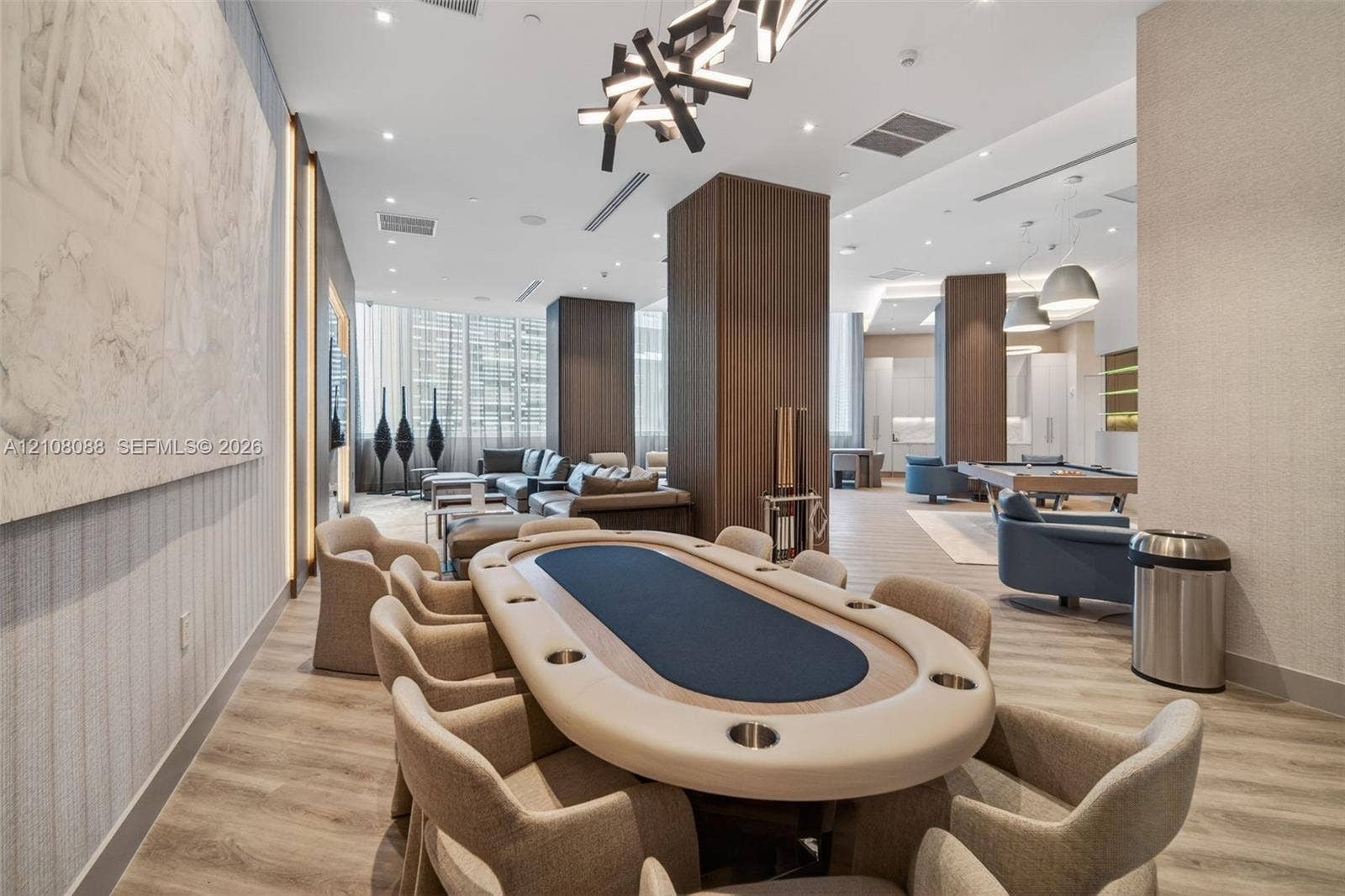 333 Las Olas Way, #2601, Fort Lauderdale, FL 33301 Expansive common area featuring wood-finish flooring, floor-to-ceiling windows, modern geometric pendant lighting, built-in structural columns with wood veneer, and recessed ceiling lighting