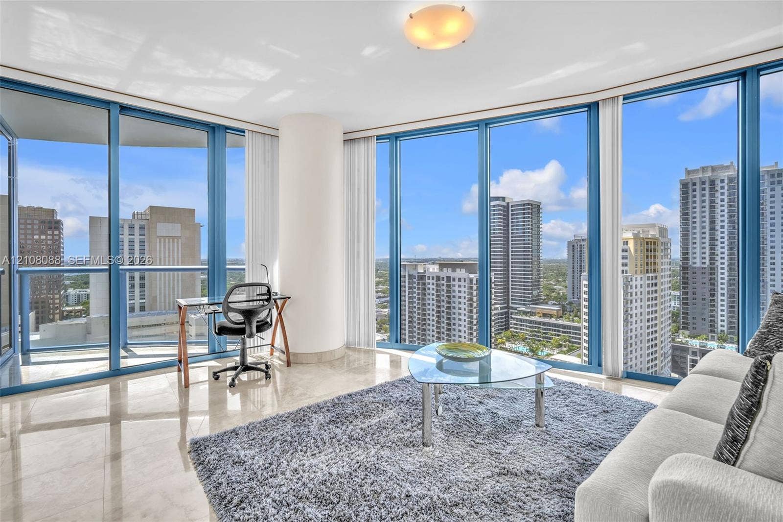 333 Las Olas Way, #2601, Fort Lauderdale, FL 33301 Floor-to-ceiling windows featuring panoramic urban scenery, polished stone flooring, and a glass balcony railing