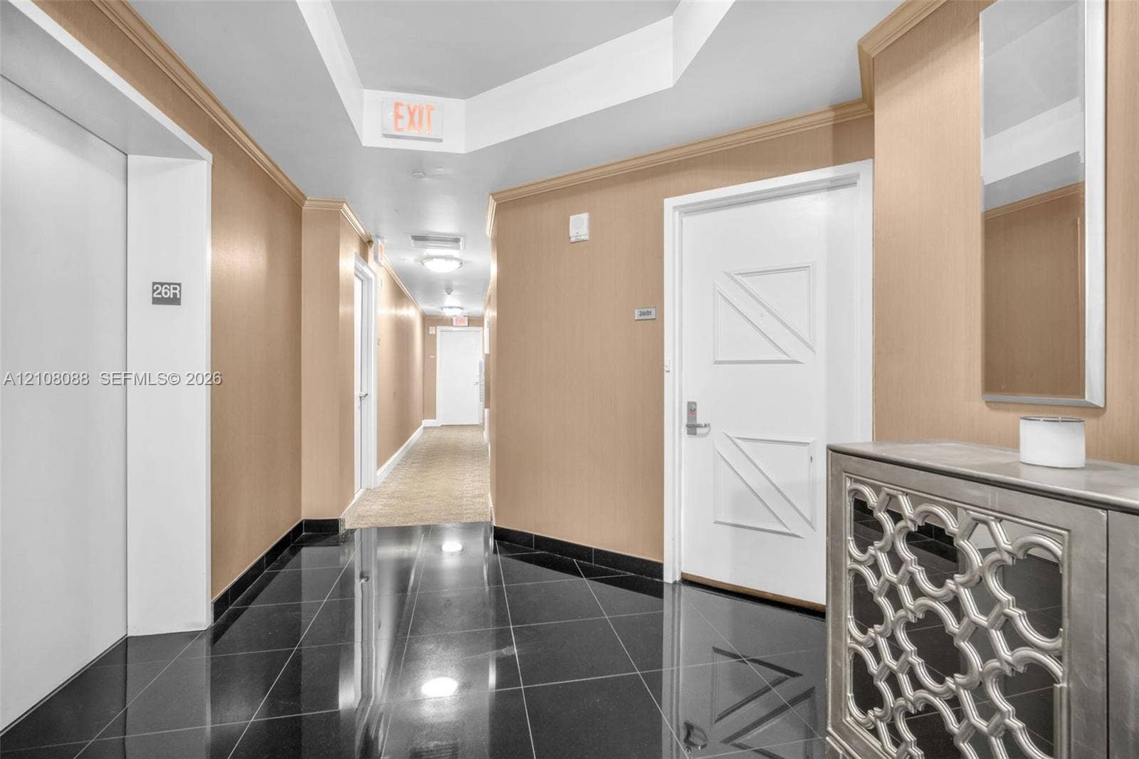 333 Las Olas Way, #2601, Fort Lauderdale, FL 33301 Semi Private Foyer Polished black tile flooring, beige wall surfacing, recessed tray ceiling, and white paneled doors