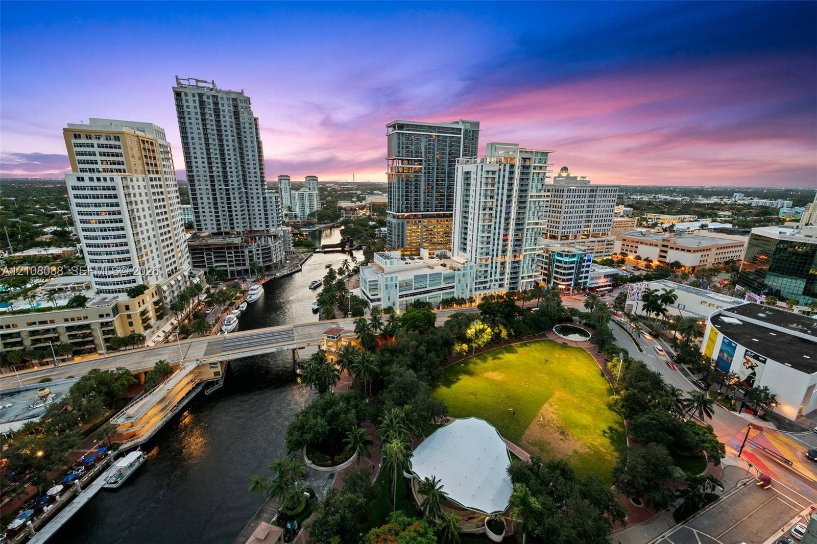 333 Las Olas Way, #2601, Fort Lauderdale, FL 33301 Aerial perspective showcasing a metropolitan skyline, a winding waterway, a central urban park with a structured pavilion, and mature landscaping