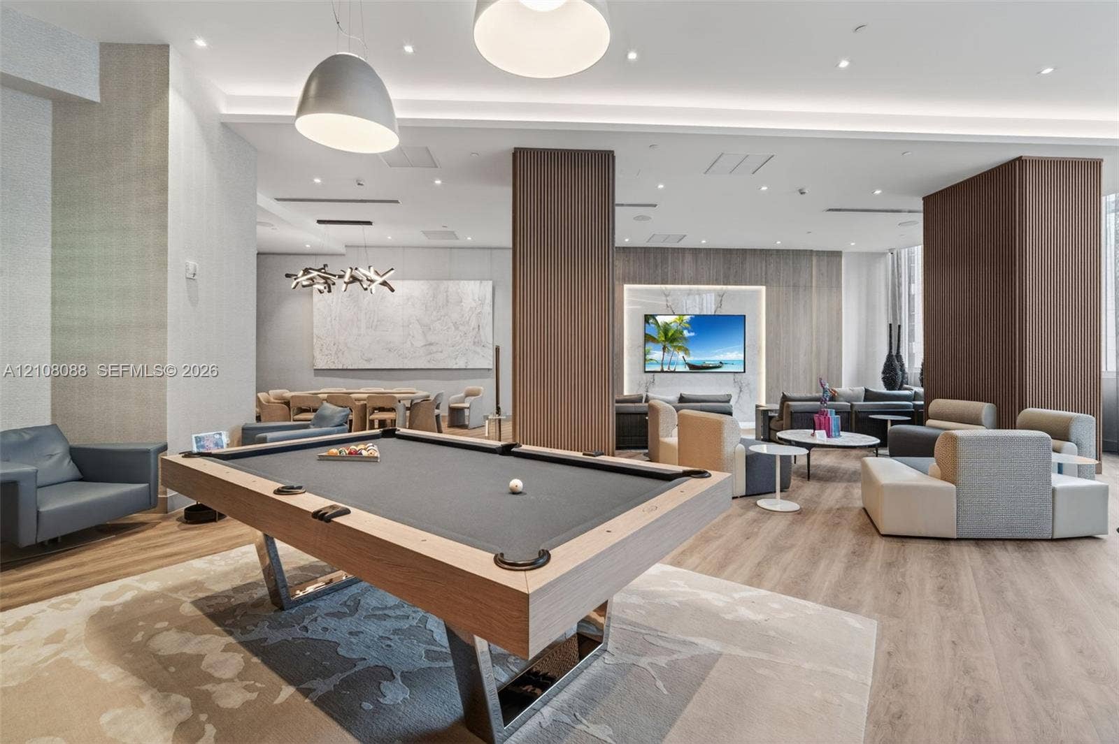 333 Las Olas Way, #2601, Fort Lauderdale, FL 33301 Common area featuring wood-finish flooring, recessed lighting, wood-paneled accent columns, and a built-in television wall feature
