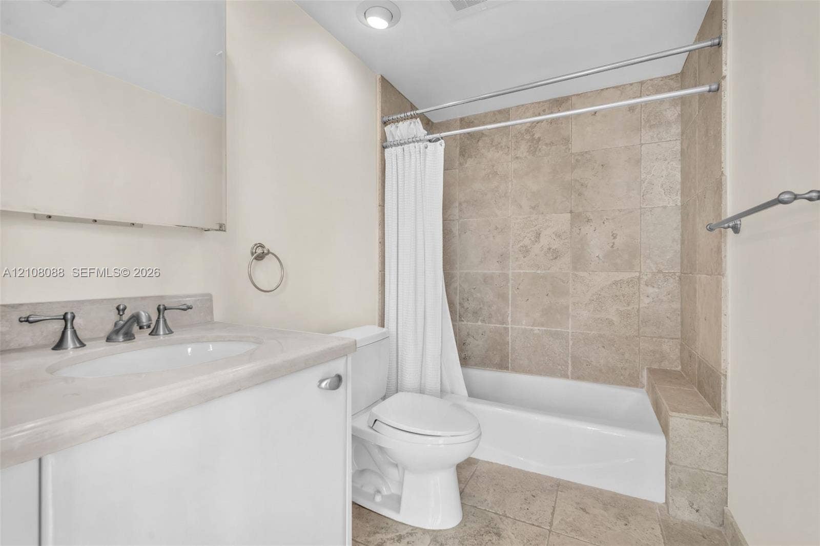 333 Las Olas Way, #2601, Fort Lauderdale, FL 33301 Bathroom featuring natural stone tile tub surround and flooring, vanity with stone countertop, recessed lighting, and metallic hardware