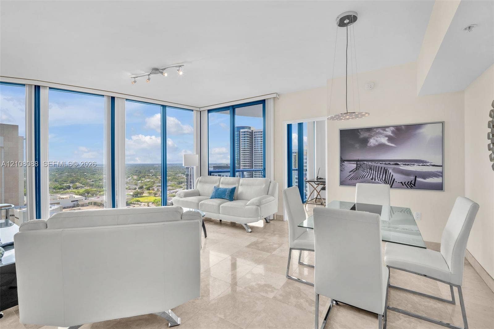333 Las Olas Way, #2601, Fort Lauderdale, FL 33301 Open-concept space featuring floor-to-ceiling windows, polished stone flooring, and suspended pendant lighting