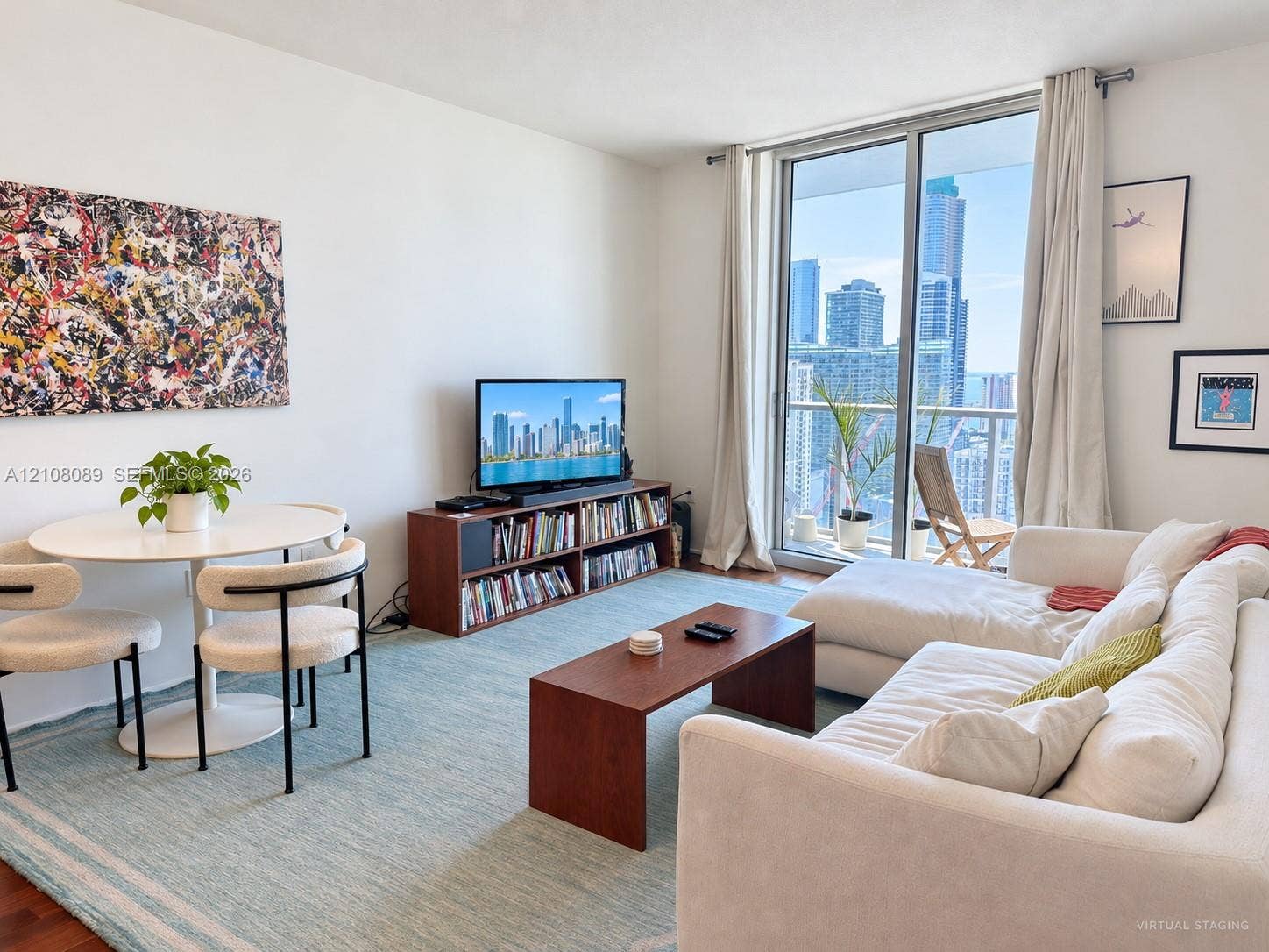 185 SW 7th Street, #3608, Miami, FL 33130 Floor-to-ceiling glass sliding doors opening to an outdoor balcony, dark wood-finish flooring, and urban skyscraper backdrop