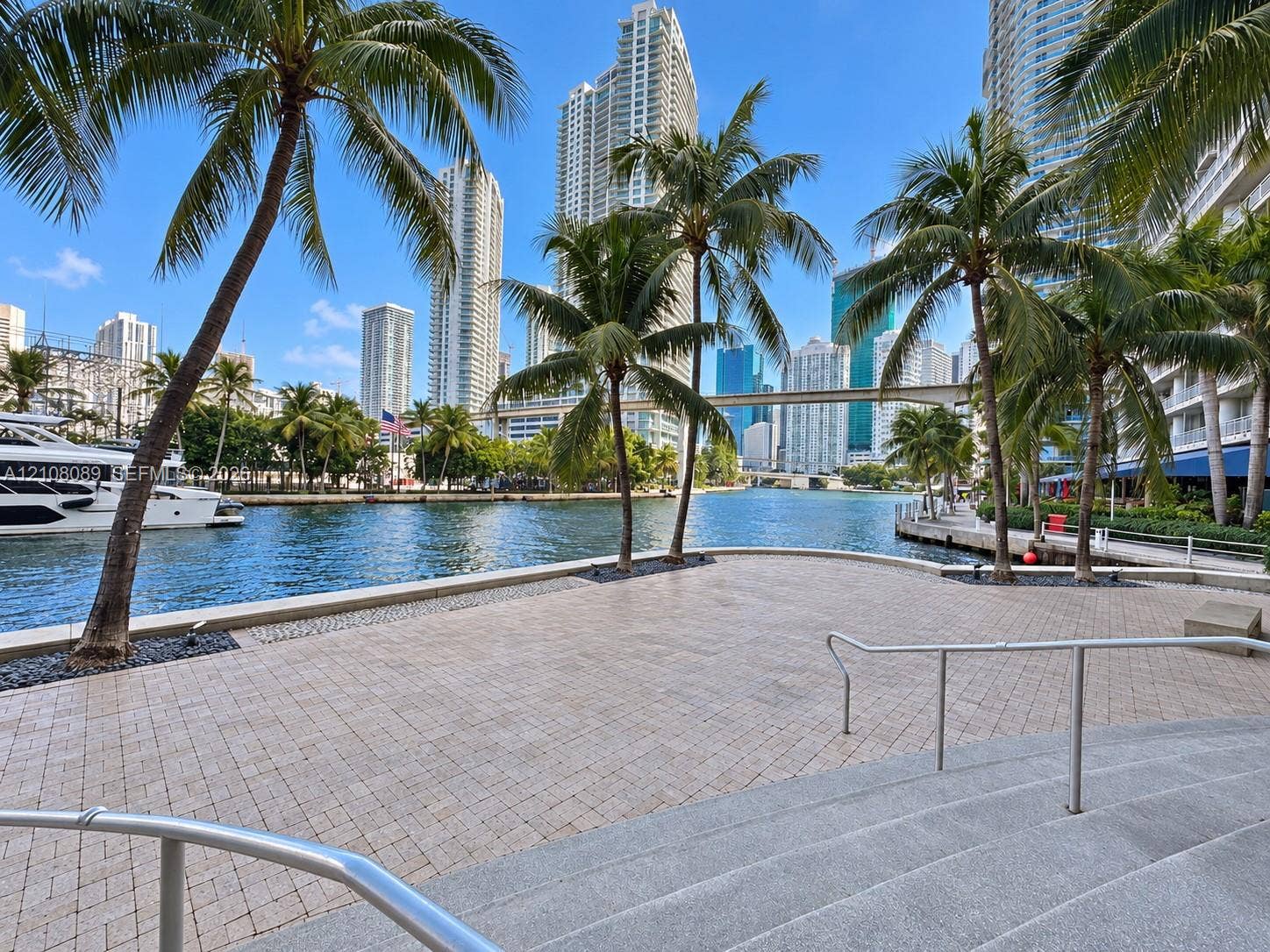 185 SW 7th Street, #3608, Miami, FL 33130 Waterfront paved terrace with stone-finish pavers, metal railings, and integrated palm tree landscaping