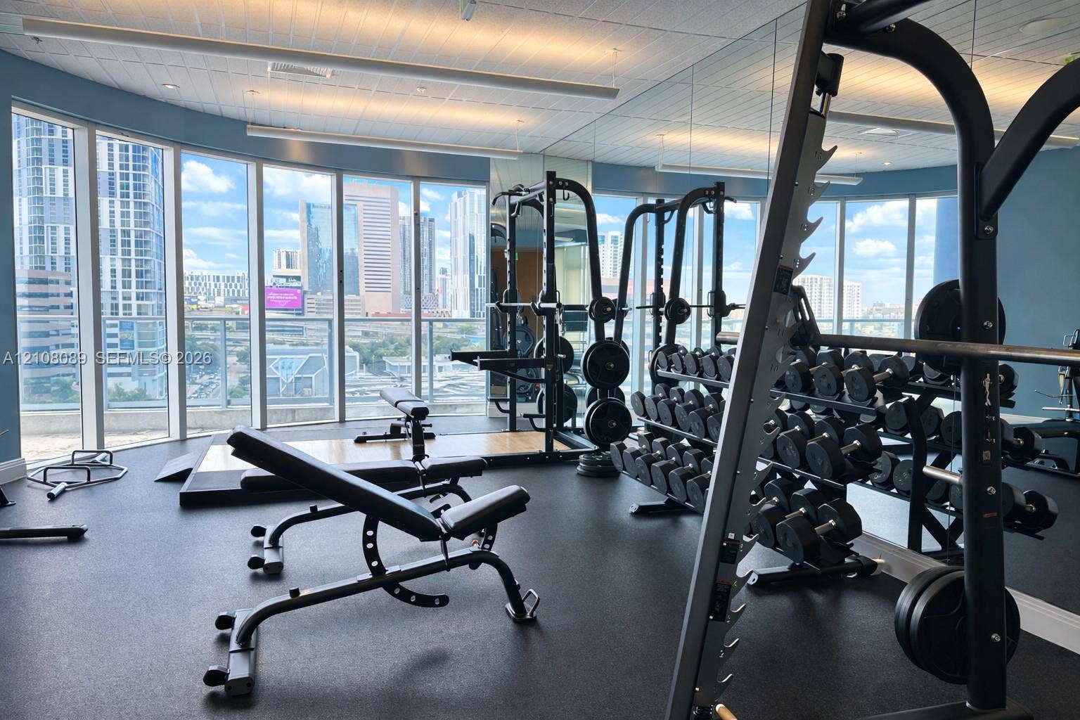 185 SW 7th Street, #3608, Miami, FL 33130 Fitness center featuring floor-to-ceiling windows, panoramic urban scenery, and mirrored walls
