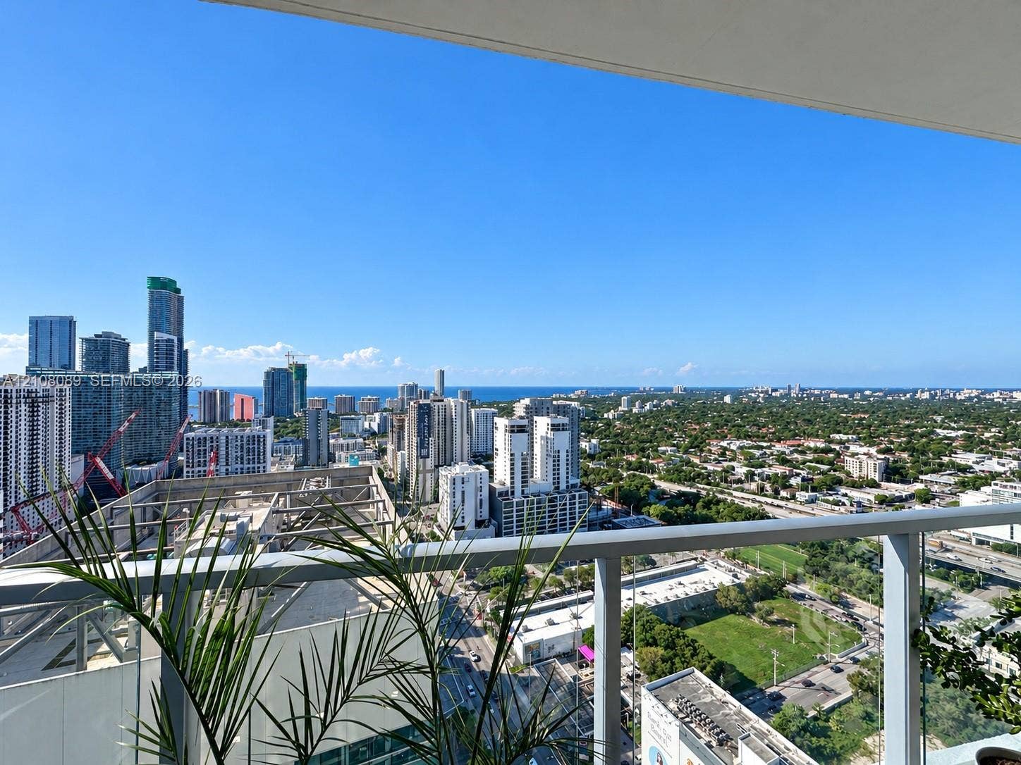 185 SW 7th Street, #3608, Miami, FL 33130 Covered balcony with a glass and metal railing offering panoramic urban and coastal scenery