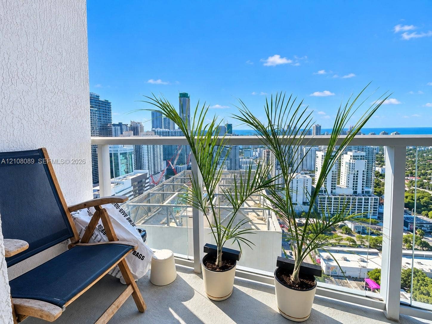 185 SW 7th Street, #3608, Miami, FL 33130 Private balcony featuring a glass panel railing and concrete flooring, overlooking the metropolitan skyline and coastline