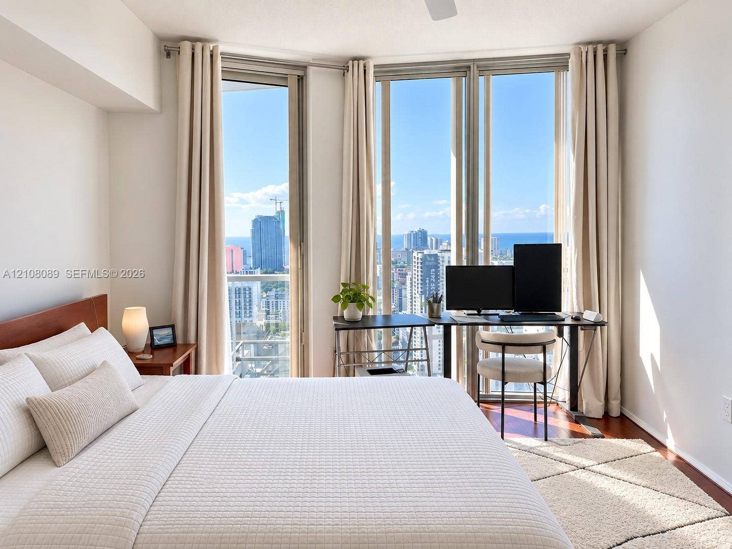 185 SW 7th Street, #3608, Miami, FL 33130 Floor-to-ceiling windows featuring urban and coastal scenery, wood-finish flooring, and a ceiling fan