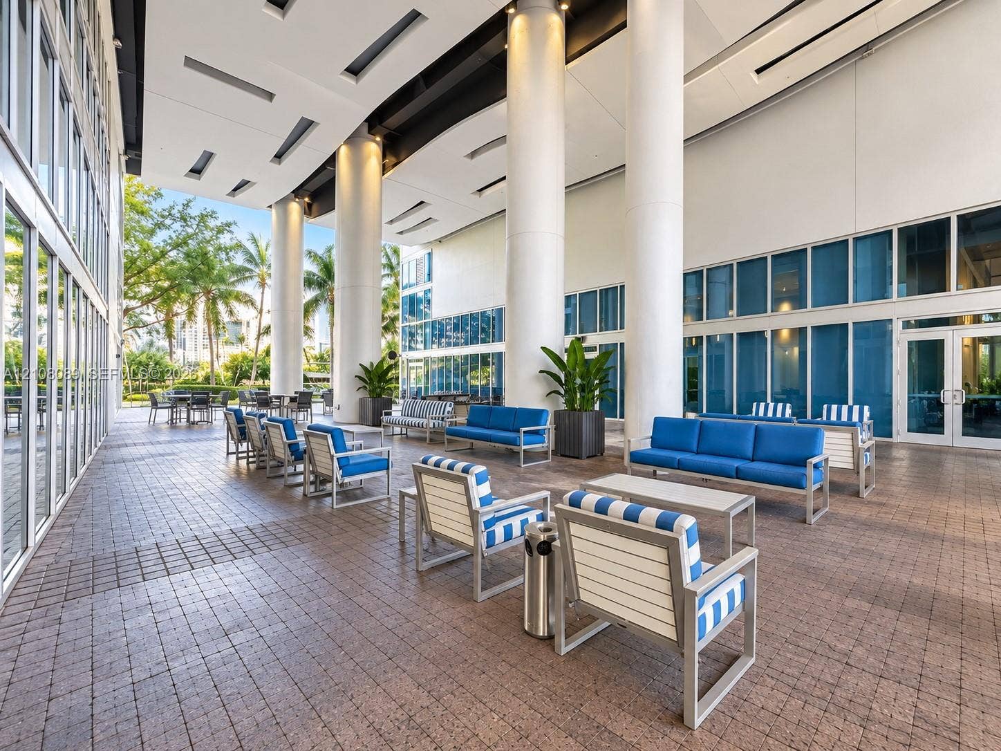 185 SW 7th Street, #3608, Miami, FL 33130 Covered outdoor terrace featuring a paver stone floor, full-height glass walls, and structural cylindrical columns with recessed ceiling lighting