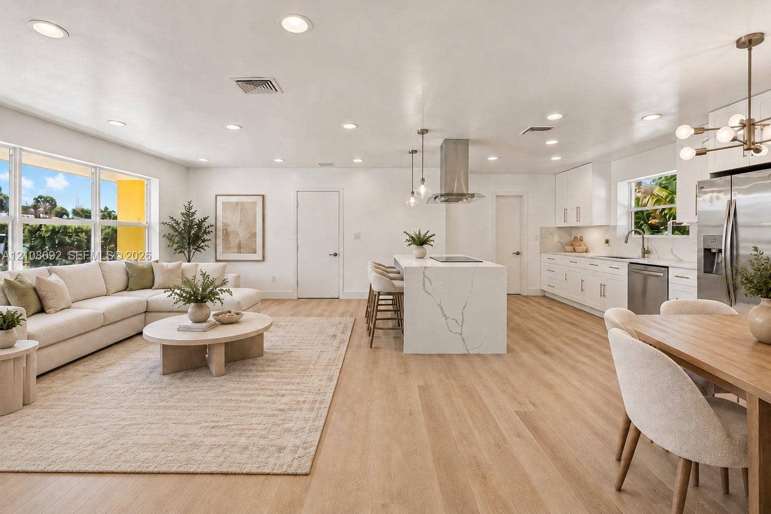 Kitchen featuring a central island with a stone-finish countertop and built-in electric cooktop, stainless steel chimney-style range hood, recessed ceiling lighting, and wood-finish flooring