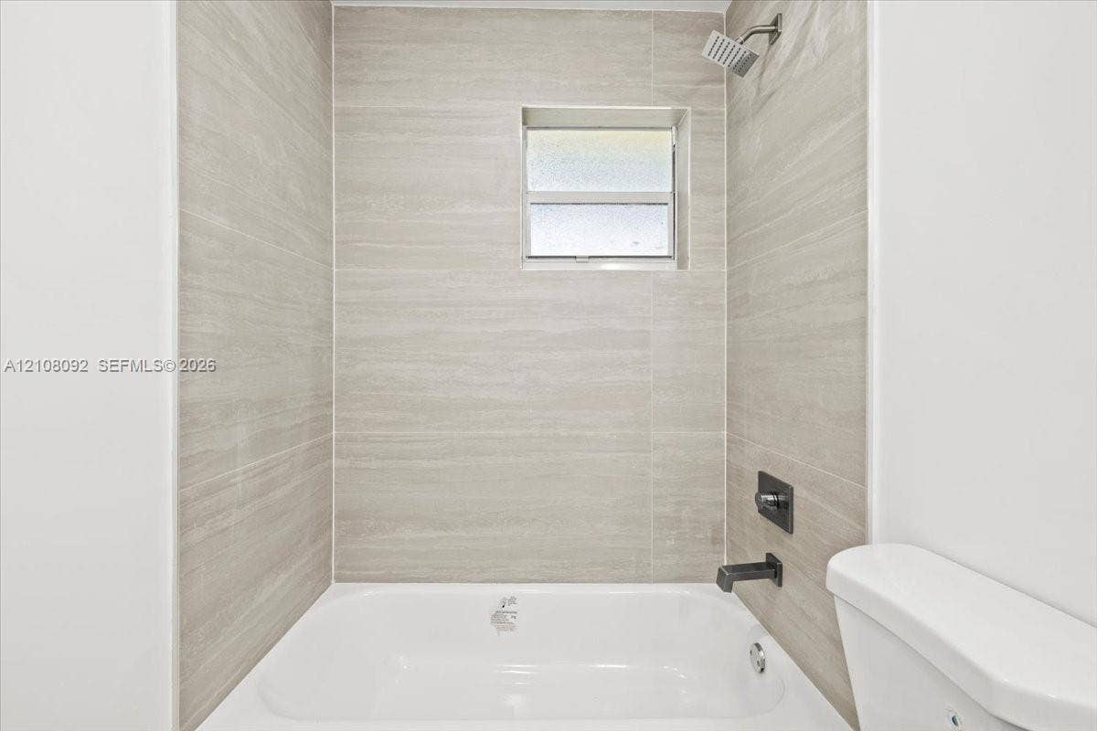 Room featuring wood-finish flooring, white walls, double-door closet, and an integrated ceiling fan with light fixture