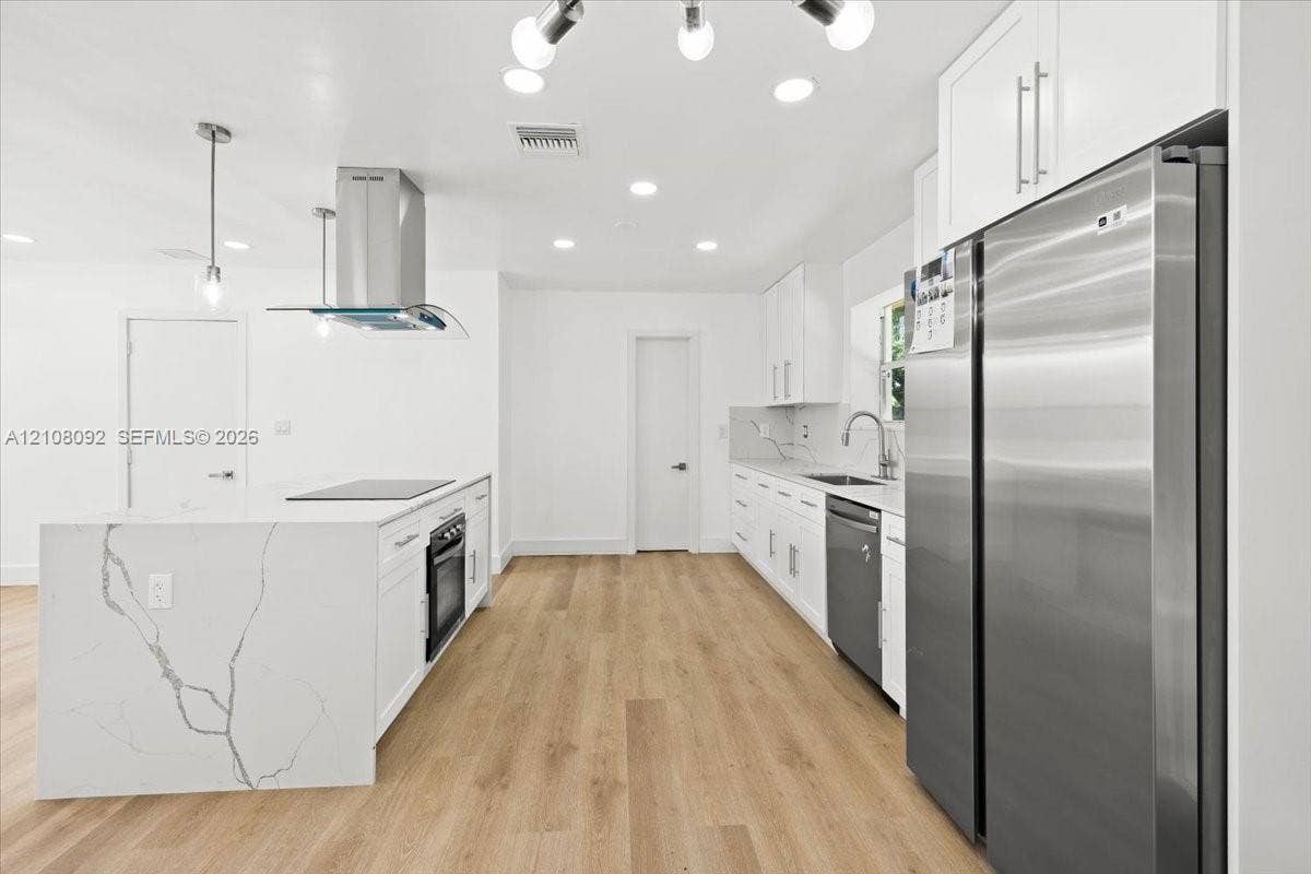 Room featuring wood-finish flooring, a neutral color palette, ceiling fan with integrated lighting, and white six-panel doors