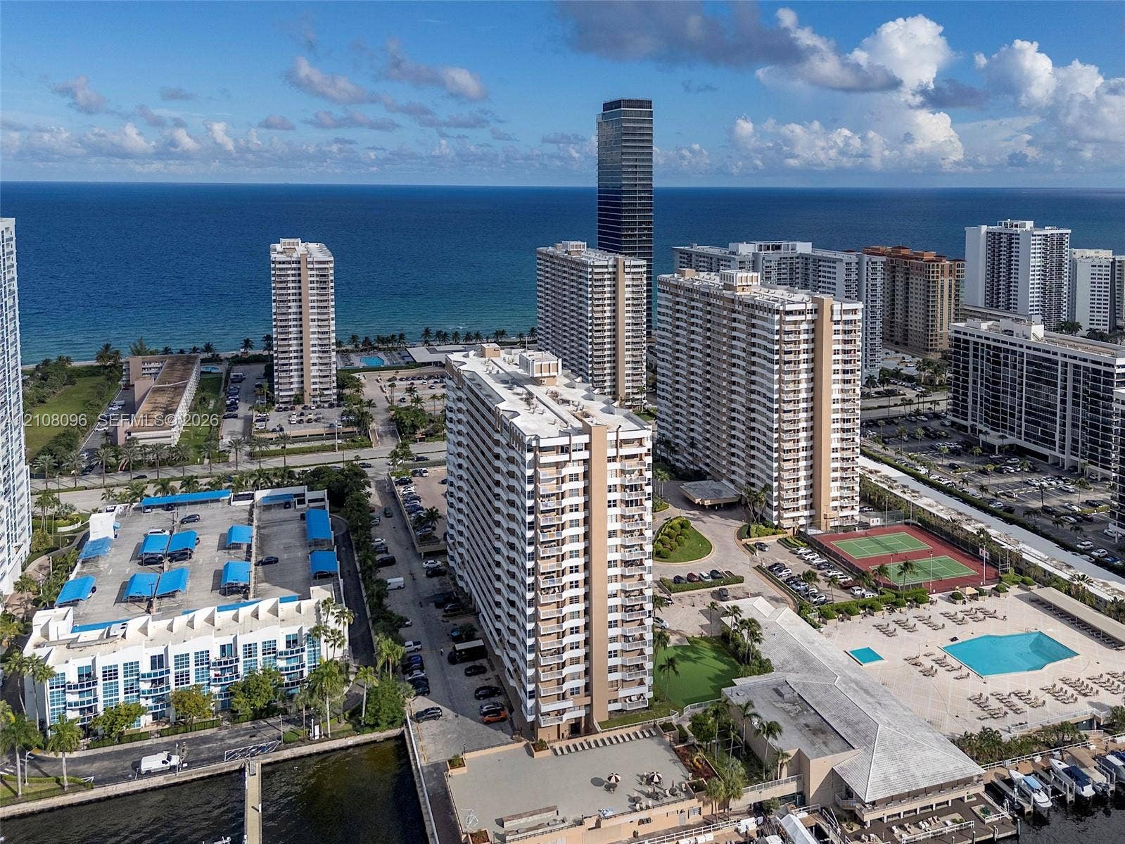 1965 S Ocean Drive, #6H, Hallandale Beach, Hallandale Beach, FL 33009 Aerial perspective of coastal residential complex featuring outdoor swimming pool, tennis court, boat slips, and parking structures