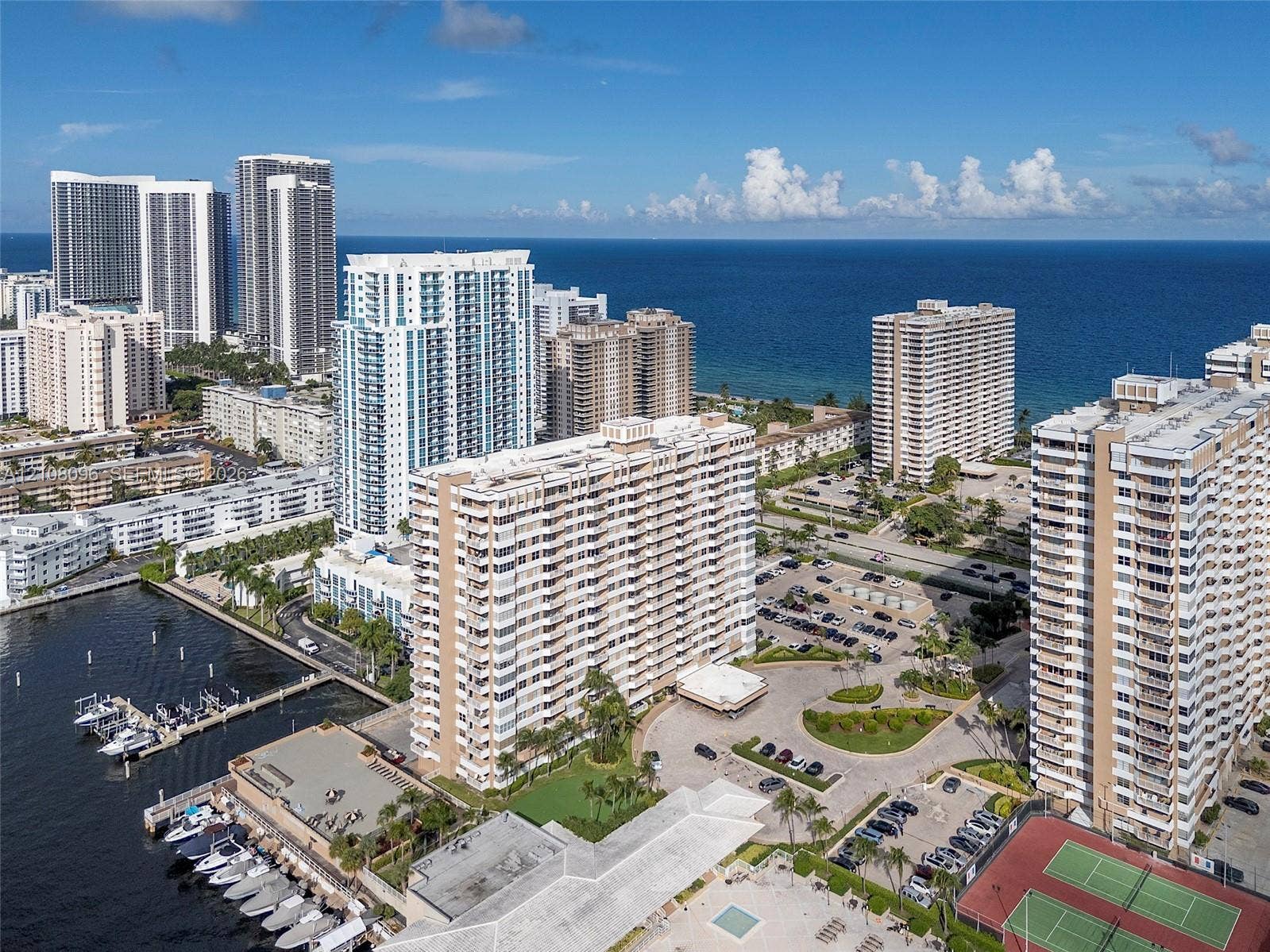 1965 S Ocean Drive, #6H, Hallandale Beach, Hallandale Beach, FL 33009 Aerial perspective of a waterfront high-rise complex featuring deep-water boat slips, paved parking facilities, multi-court tennis area, and proximity to oceanfront coastline