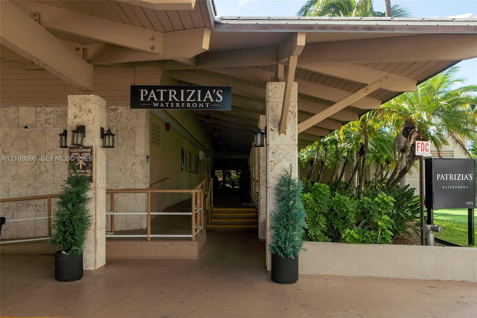 1965 S Ocean Drive, #6H, Hallandale Beach, Hallandale Beach, FL 33009 Covered entryway featuring natural stone column cladding, exposed beam ceiling structure, and metal handrails