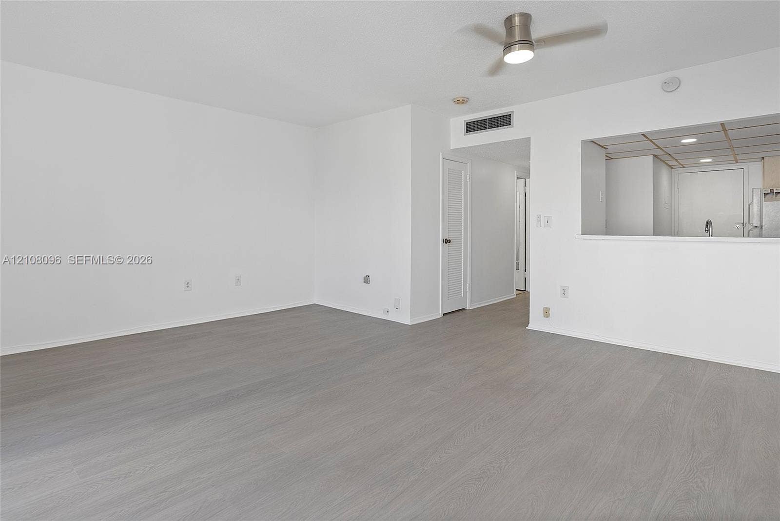 1965 S Ocean Drive, #6H, Hallandale Beach, Hallandale Beach, FL 33009 Open living area featuring wood-finish flooring, neutral wall paint, and a ceiling-mounted light fixture with fan