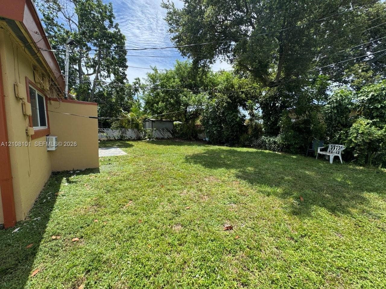 6318 Buchanan Street, #2, Hollywood, Hollywood, FL 33024 Expansive backyard featuring a lawn, perimeter fencing, and mature trees