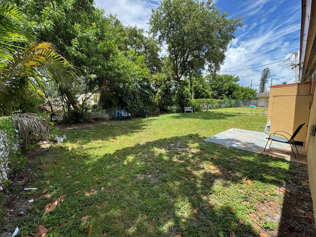 6318 Buchanan Street, #2, Hollywood, Hollywood, FL 33024 Backyard featuring a concrete patio, perimeter chain-link fencing, and mature trees