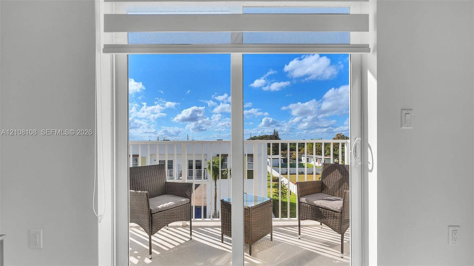 605 N Dixie Highway, #B207, Hallandale Beach, Hallandale Beach, FL 33009 Sliding glass door with integrated roller shade, featuring a white frame and access to a balcony with vertical metal railing