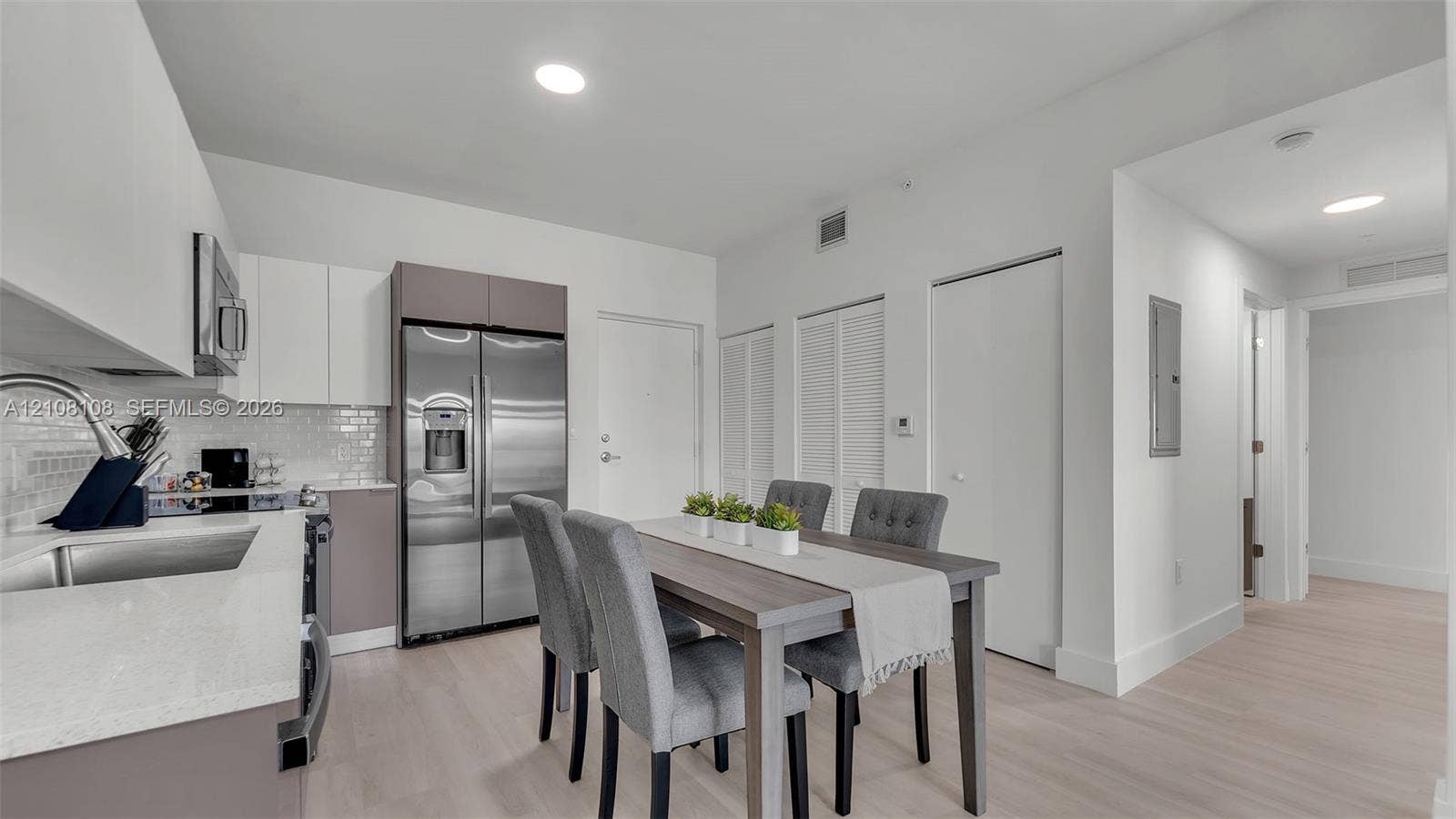 605 N Dixie Highway, #B207, Hallandale Beach, Hallandale Beach, FL 33009 Kitchen featuring stainless steel appliances, white cabinetry, a subway tile backsplash, light-toned wood-finish flooring, and recessed lighting
