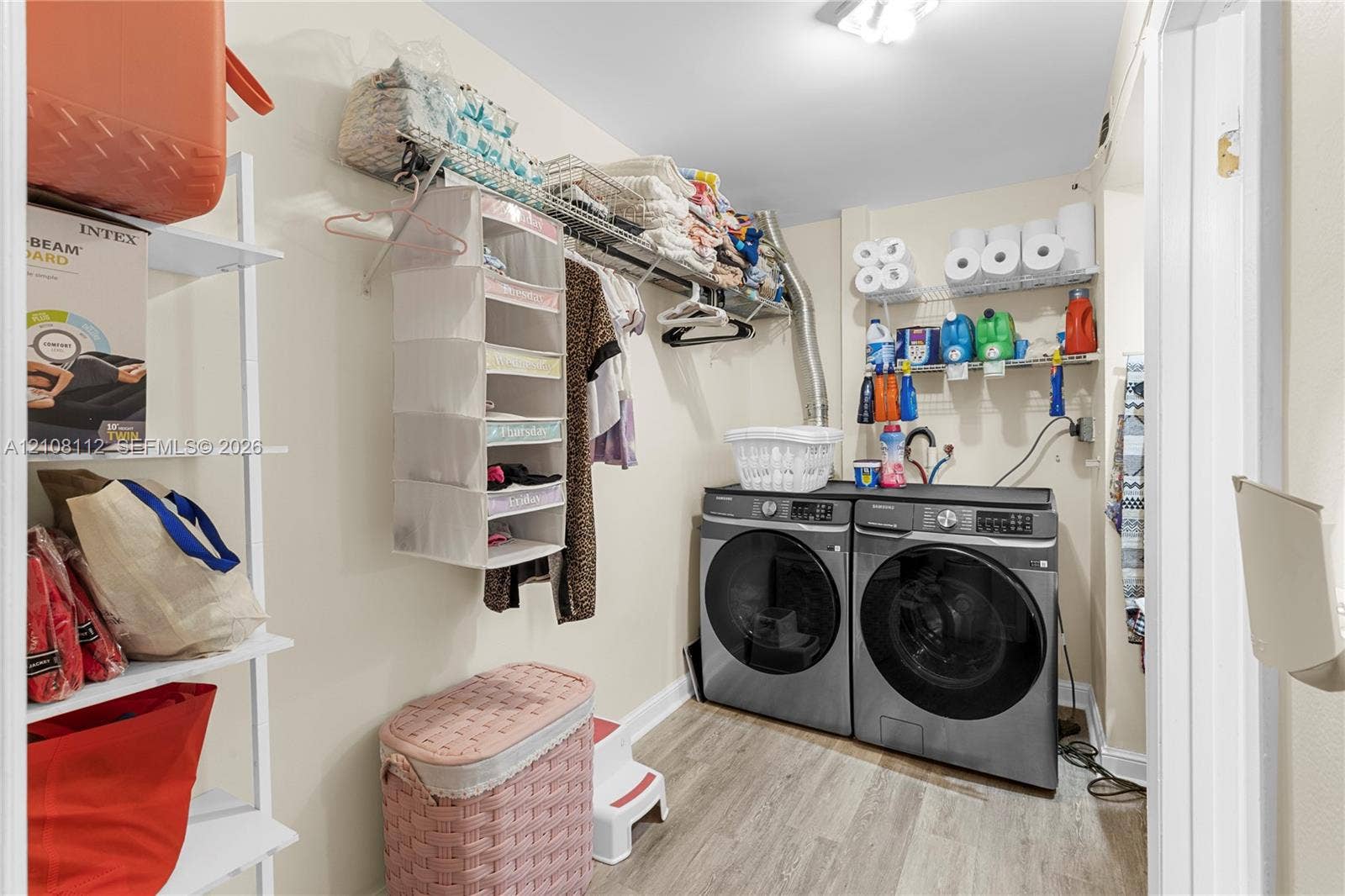 1431 NW 112th Terrace, Pembroke Pines, FL 33026 Utility space featuring wood-finish flooring, white wire wall-mounted shelving, and laundry hookups