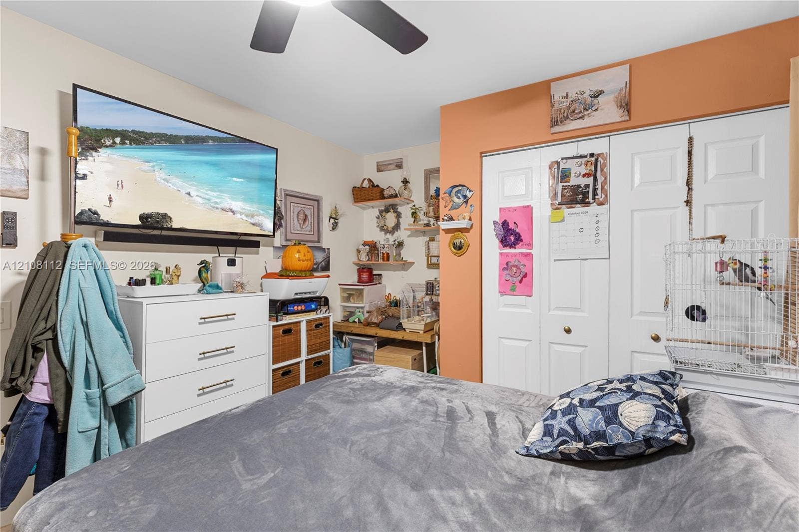1431 NW 112th Terrace, Pembroke Pines, FL 33026 Room featuring double-panel closet doors, wall-mounted shelving, and a ceiling fan