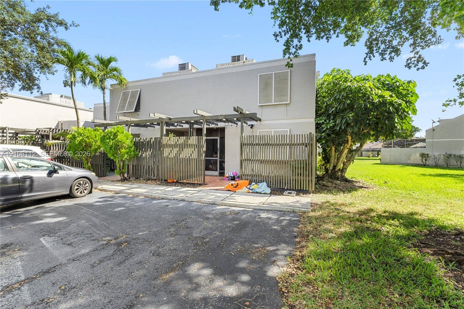 1431 NW 112th Terrace, Pembroke Pines, FL 33026 Two-story exterior featuring a pergola, fenced patio, paved walkway, and white louvered shutters