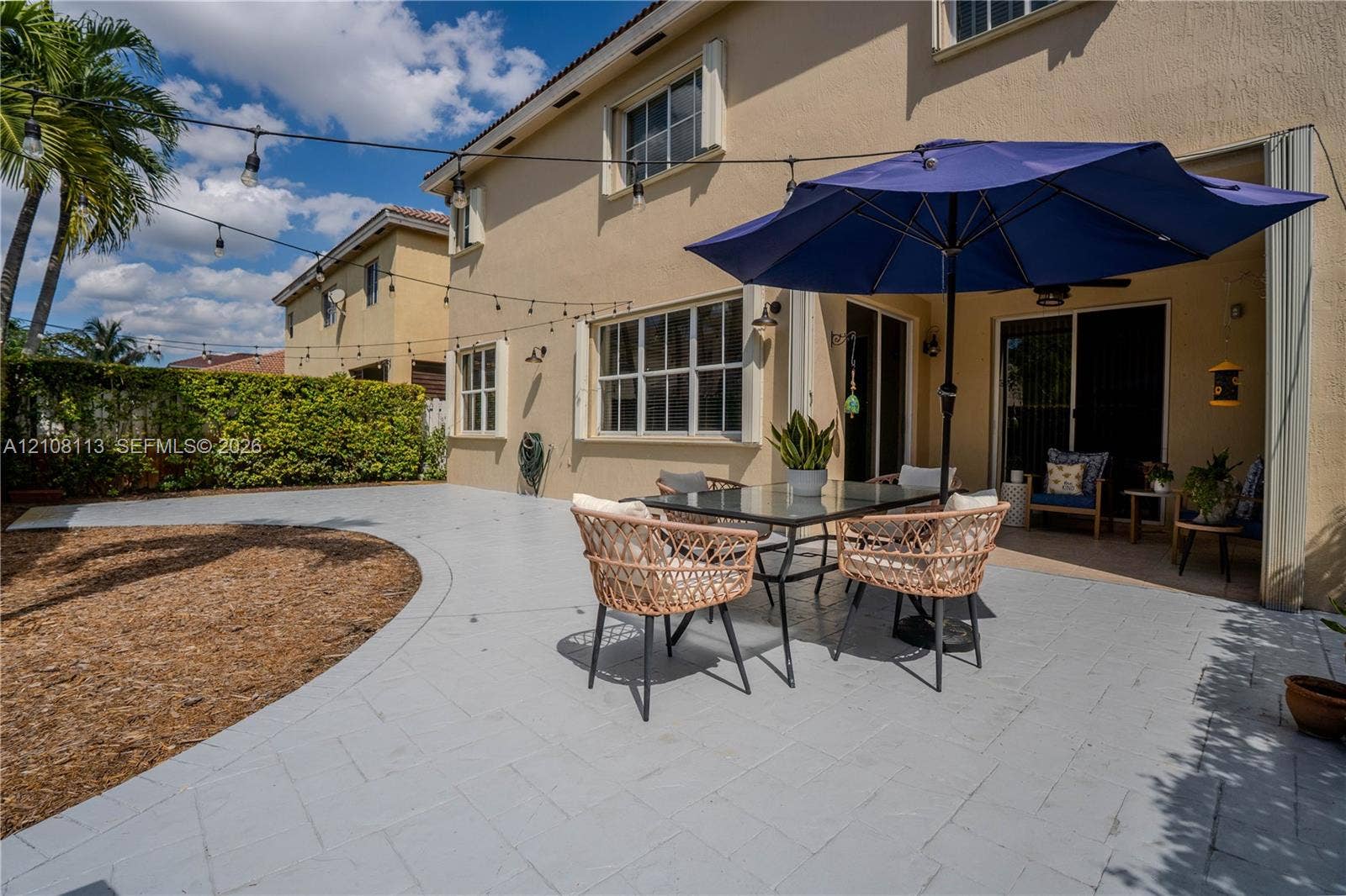 2294 SW 126th Avenue, Miramar, FL 33027 Stucco exterior featuring a paved patio, covered porch area, and integrated string lighting