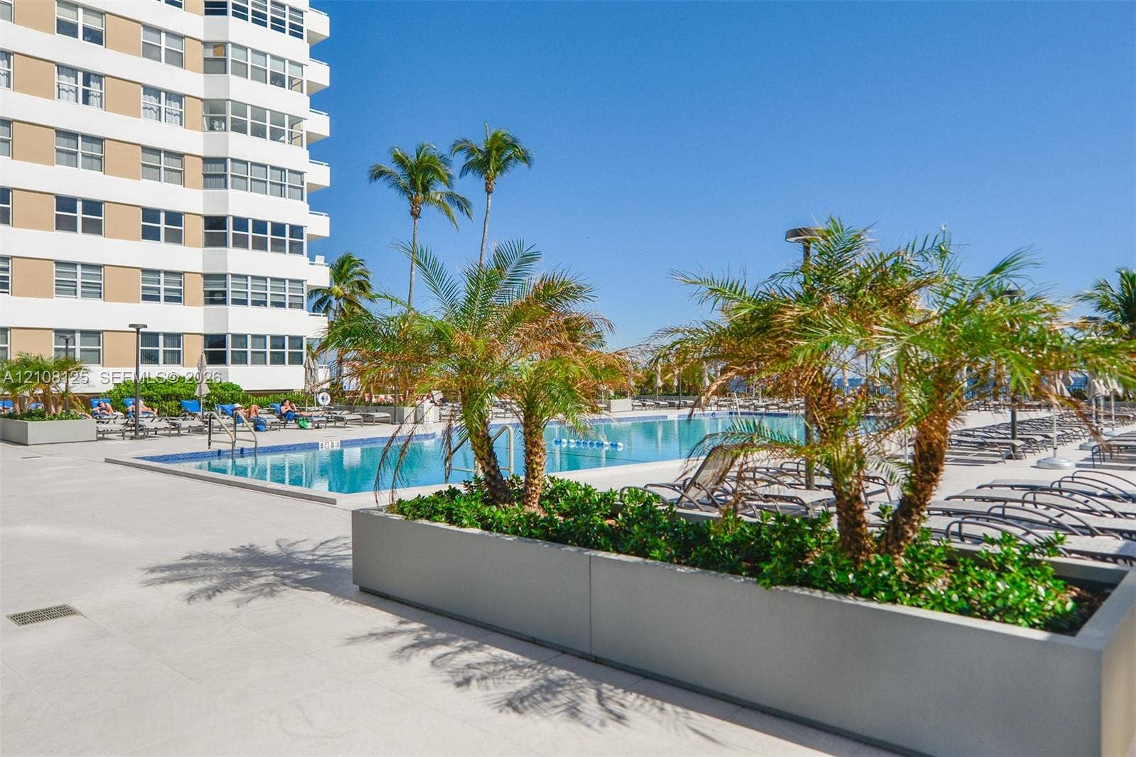1985 S Ocean Drive, #8M, Hallandale Beach, FL 33009 Swimming pool with tile edging, concrete pool deck, and raised rectangular planters