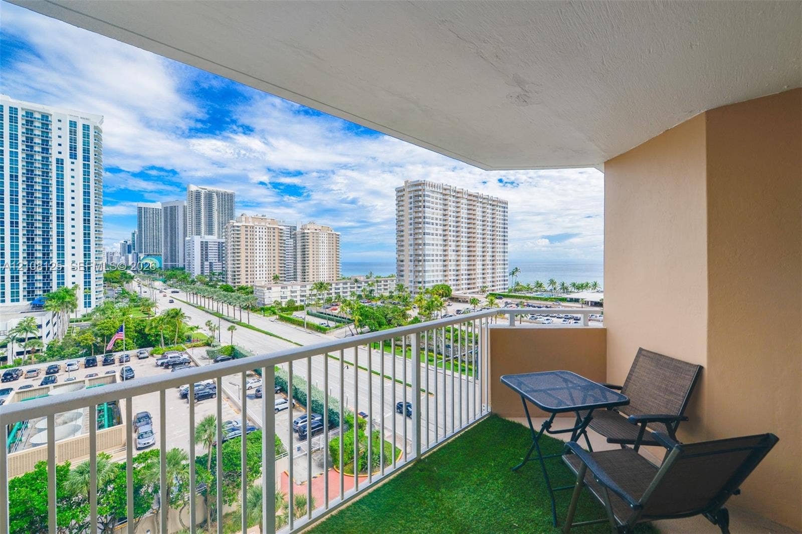 1985 S Ocean Drive, #8M, Hallandale Beach, FL 33009 Covered balcony featuring a white metal railing and outdoor turf flooring