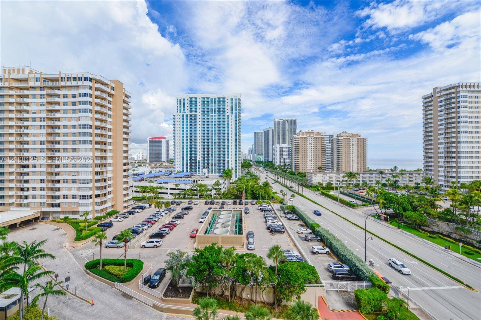 1985 S Ocean Drive, #8M, Hallandale Beach, FL 33009 High-rise urban setting featuring paved surface parking, mature palm trees, multi-story residential structures, and proximity to major roadways