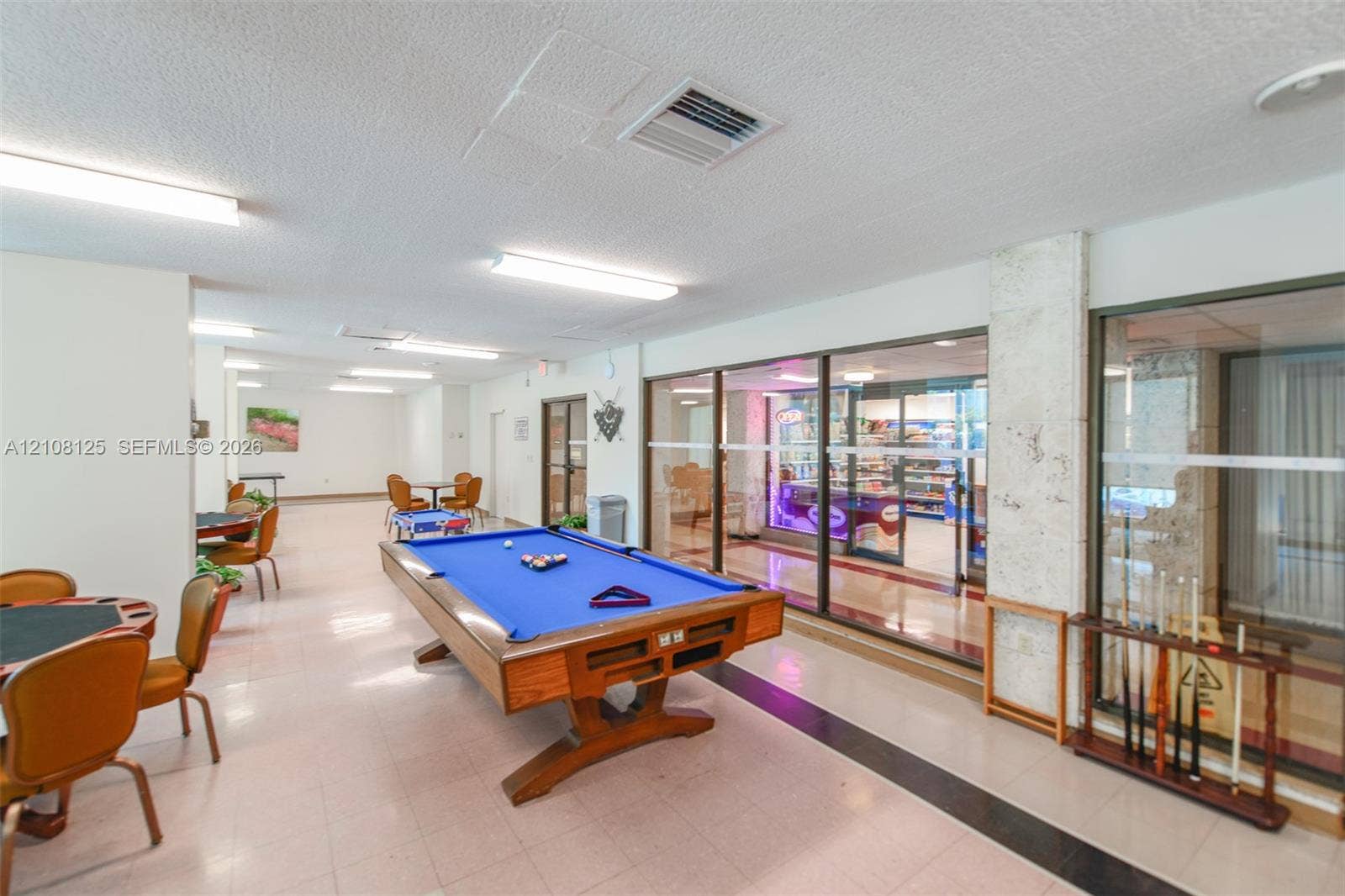 1985 S Ocean Drive, #8M, Hallandale Beach, FL 33009 Open-concept recreation space featuring ceramic tile flooring, linear overhead lighting, and expansive glass partition walls