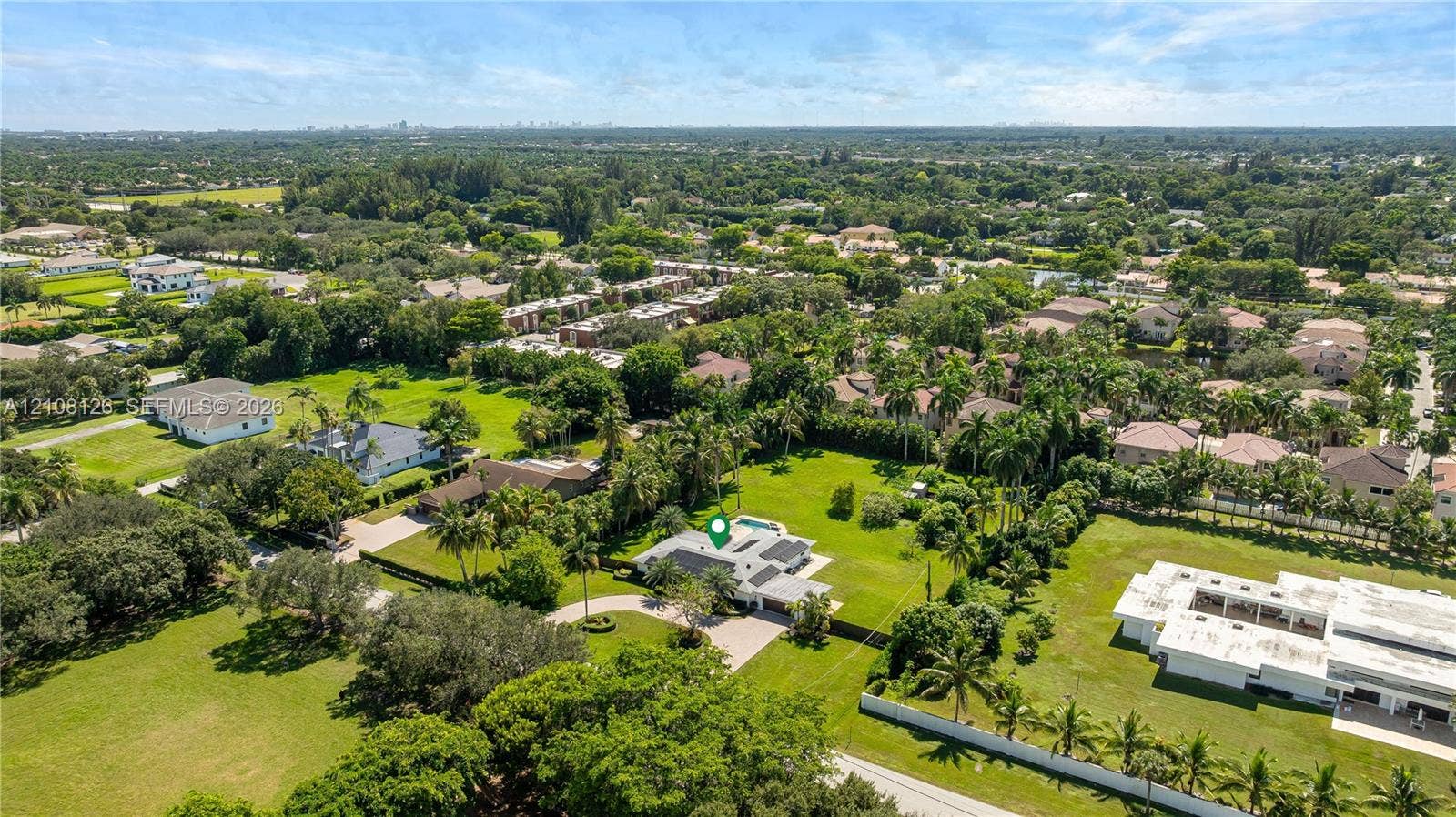 11700 NW 4th Street, Plantation, Plantation, FL 33325 Aerial perspective of a sprawling property featuring a circular driveway, expansive manicured grounds, mature palm trees, and an in-ground swimming pool