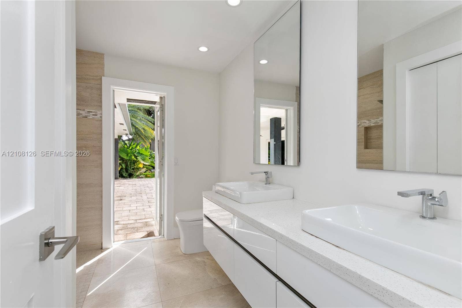 11700 NW 4th Street, Plantation, Plantation, FL 33325 Modern floating vanity with dual rectangular vessel sinks, quartz countertops, and polished chrome faucets, complemented by wall-to-wall mirrors and stone tile flooring