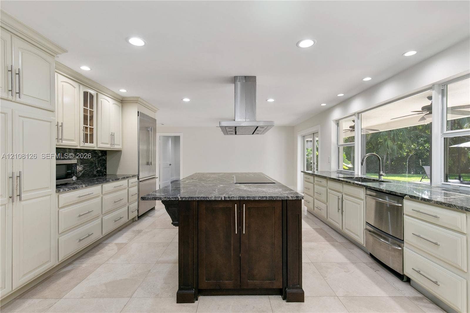 11700 NW 4th Street, Plantation, Plantation, FL 33325 Kitchen featuring light-toned cabinetry, a dark-toned center island with a built-in cooktop, stainless steel range hood, stone-finish countertops, and tile flooring