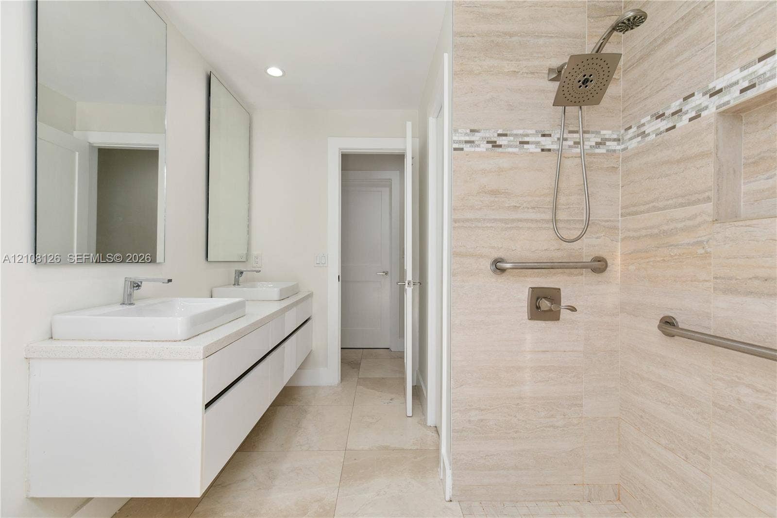 11700 NW 4th Street, Plantation, Plantation, FL 33325 Floating vanity with dual rectangular vessel sinks, wall-mounted rectangular mirrors, walk-in shower with stone-finish tile surround, built-in shower niche, and metallic grab bars