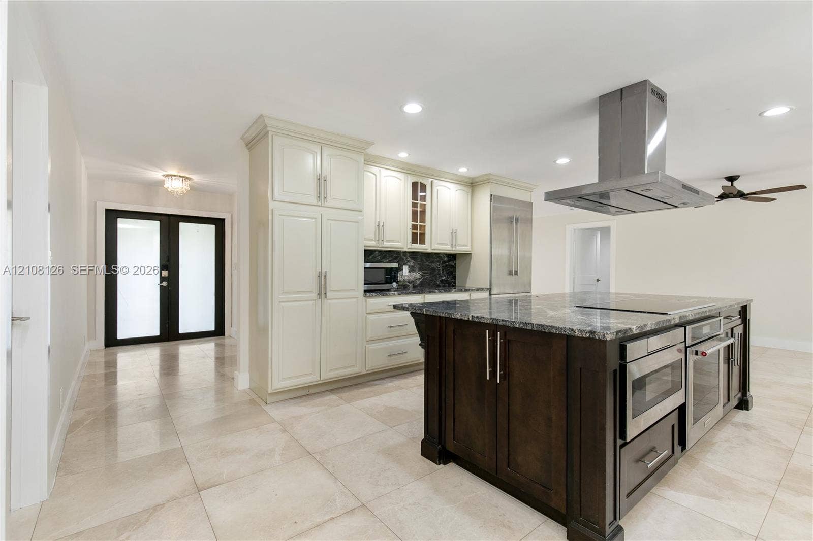 11700 NW 4th Street, Plantation, Plantation, FL 33325 Kitchen featuring an expansive center island with stone countertop, stainless steel professional-grade appliances, built-in cabinetry, polished stone flooring, and a stainless steel ceiling-mounted vent hood