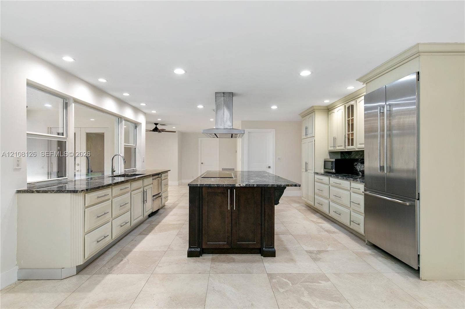 11700 NW 4th Street, Plantation, Plantation, FL 33325 Kitchen featuring a central island with a stone countertop, custom cabinetry, stainless steel refrigerator, stone-tiled flooring, and recessed ceiling lighting