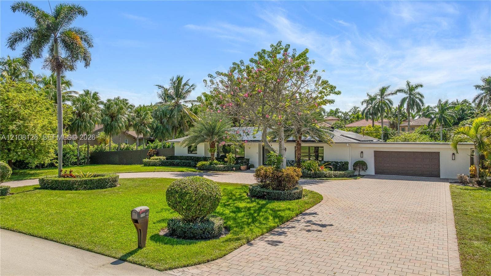 11700 NW 4th Street, Plantation, Plantation, FL 33325 Single-story exterior featuring a paver driveway, an attached garage, and manicured landscaping with mature palm trees