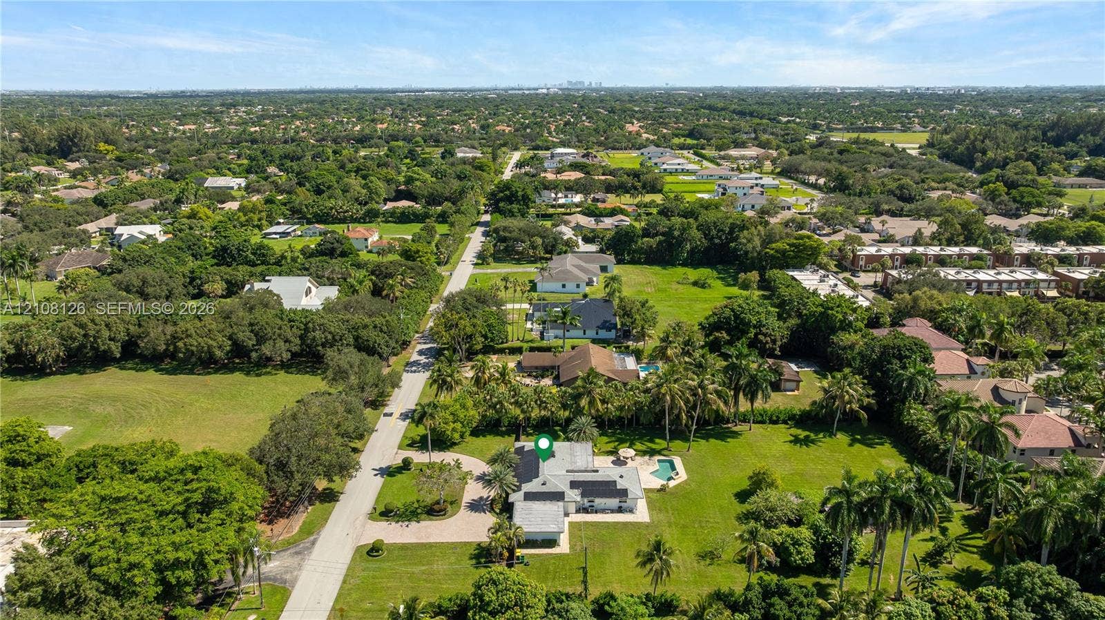11700 NW 4th Street, Plantation, Plantation, FL 33325 Aerial view of property featuring a circular paved driveway, expansive lawn, mature palm trees, and an in-ground swimming pool