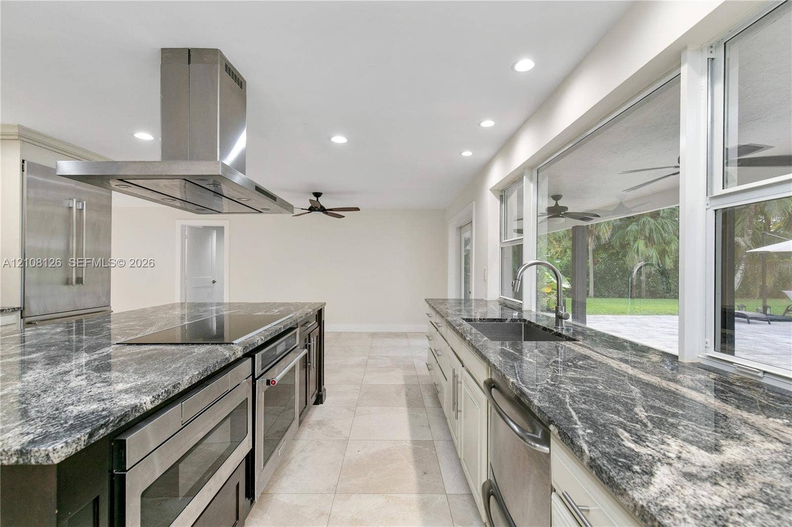 11700 NW 4th Street, Plantation, Plantation, FL 33325 Kitchen featuring polished stone countertops, stainless steel appliances, a ceiling-mounted range hood, light-toned tile flooring, and large windows